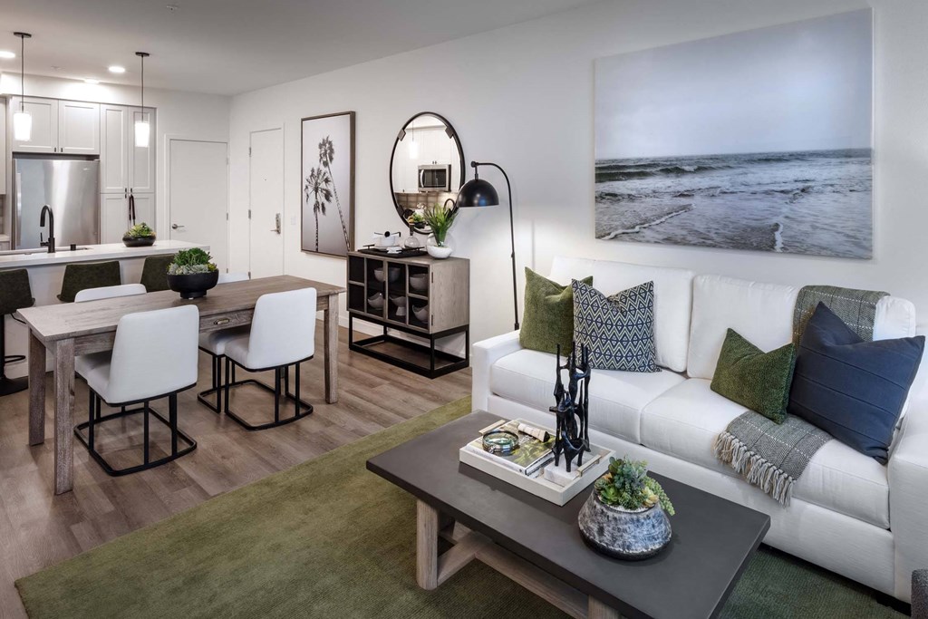 a living room and dining room with a couch and a table at Luma at El Corazon Apartments, Oceanside, California
