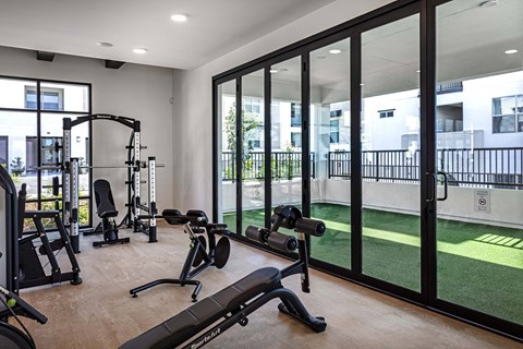 a home gym with exercise equipment and glass windows at Luma at El Corazon Apartments, Oceanside, 92056