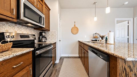 A kitchen with wooden cabinets and granite countertops.