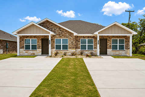 A house with a brown roof and a grey front yard.