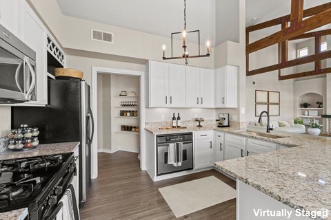 A kitchen with a black stove top oven and white cabinets.