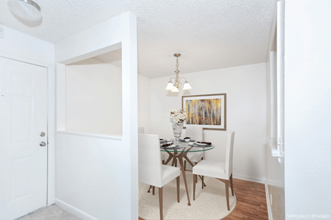 a dining room with a glass table and white chairs