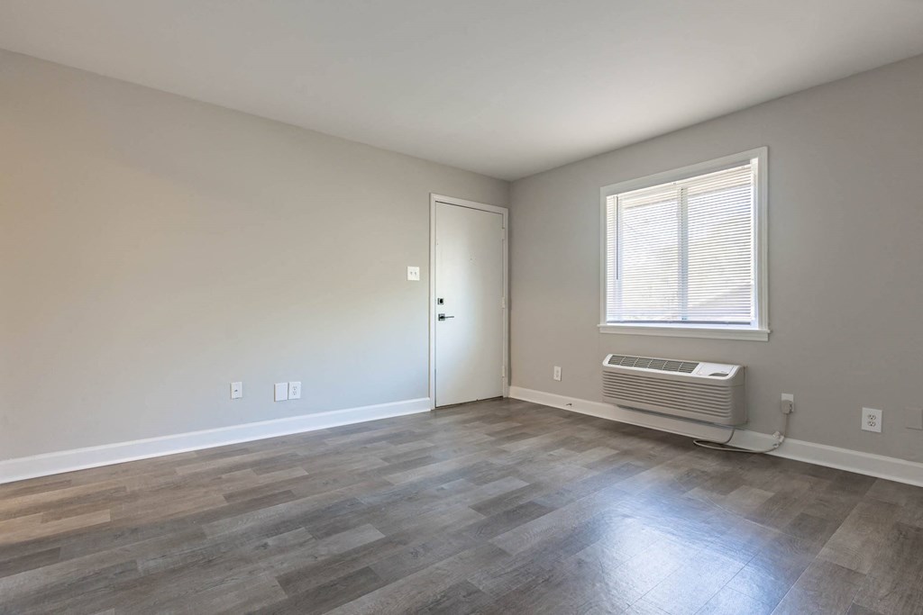 the living room of a house with wood floors and a window