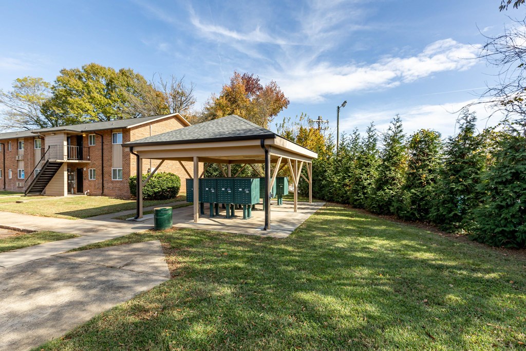 a park with a bench and a gazebo in front of a house