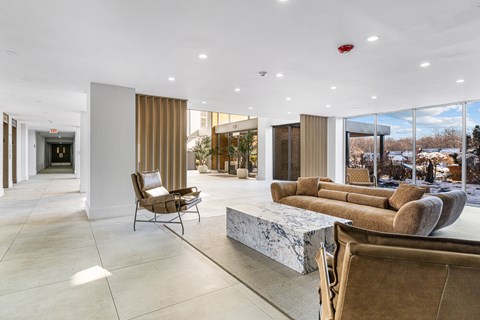 A modern living room with a marble table and brown couches.