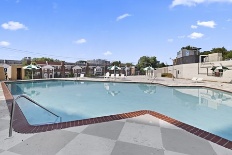 A large outdoor swimming pool with a red and white checkered floor.