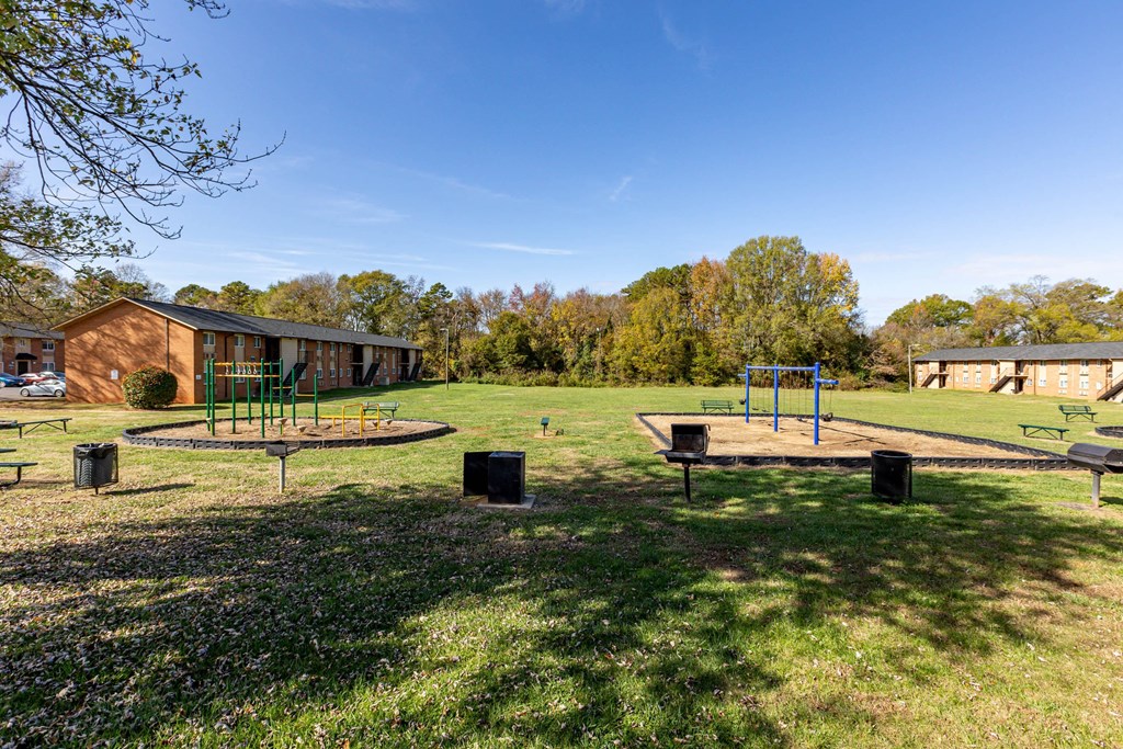 a park with a playground and houses in the background