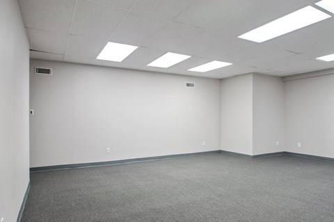 A large empty room with carpeted floor and white walls.