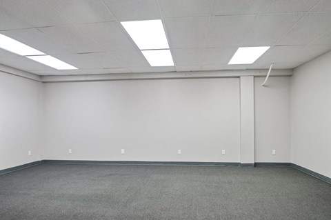 A large empty room with a carpeted floor and white walls.