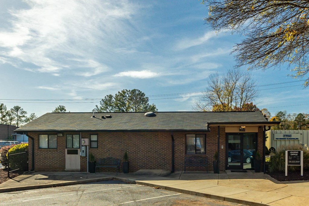 the front of a brick building with a parking lot