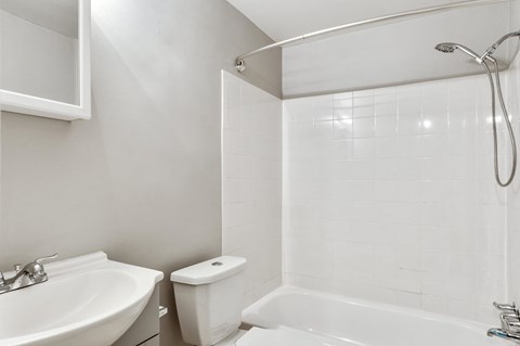 A white bathroom with a sink, toilet, and bathtub.