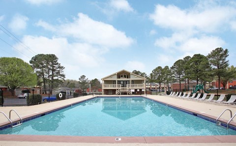 A large swimming pool with a building in the background.