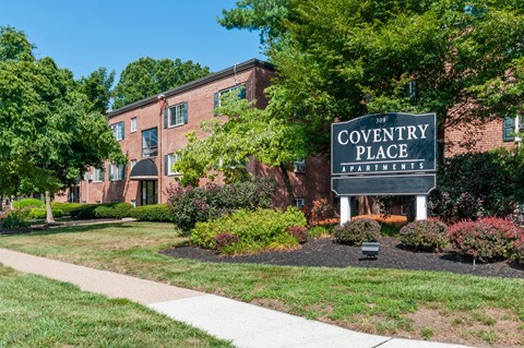 A brick building with a sign that says Coventry Place Apartments.