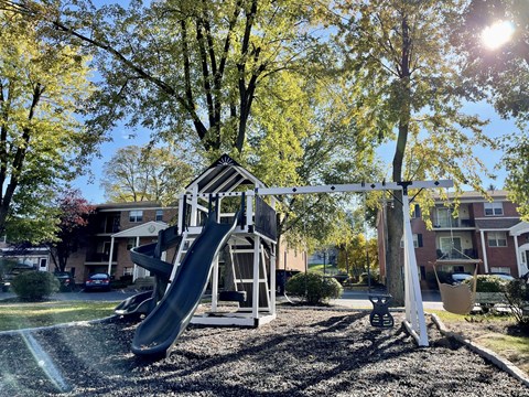 A playground with a slide and a swing set.