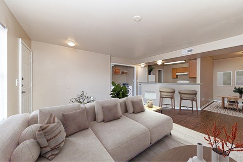 A living room with a large couch and a dining area in the background.