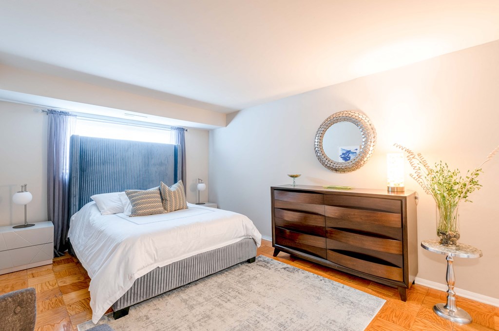 a bedroom with a bed and a dresser and a window