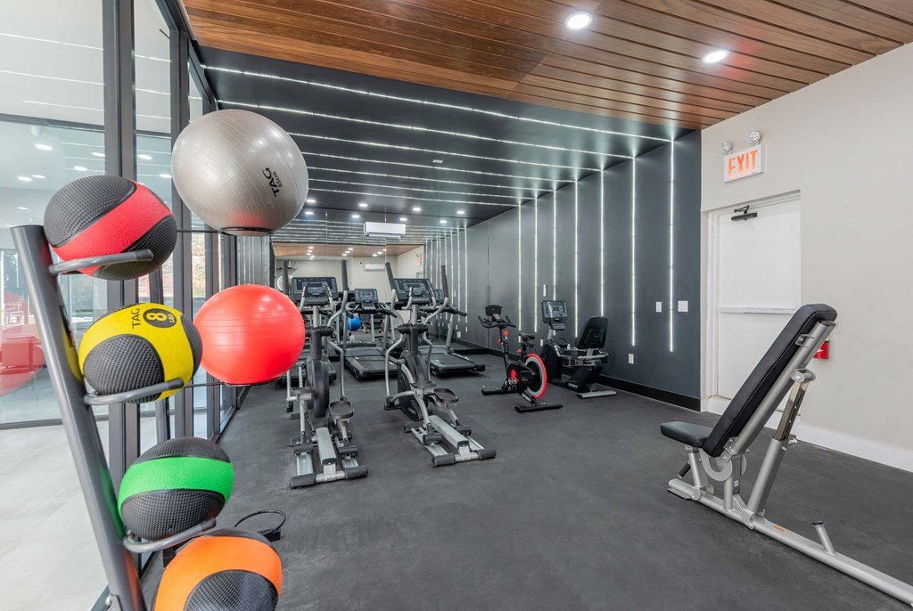 a gym with weights and cardio equipment in a building