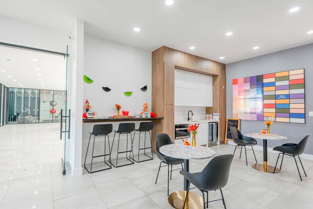 a kitchen and dining area with a table and chairs and a counter with a bar