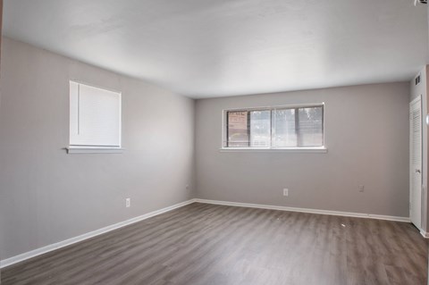 A room with a window and wooden flooring.