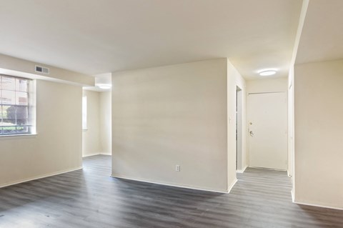A spacious room with a door on the right and a window on the left.