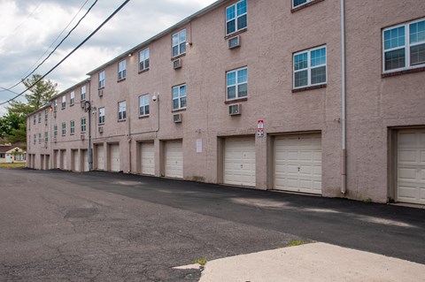 A long building with a parking lot in front.
