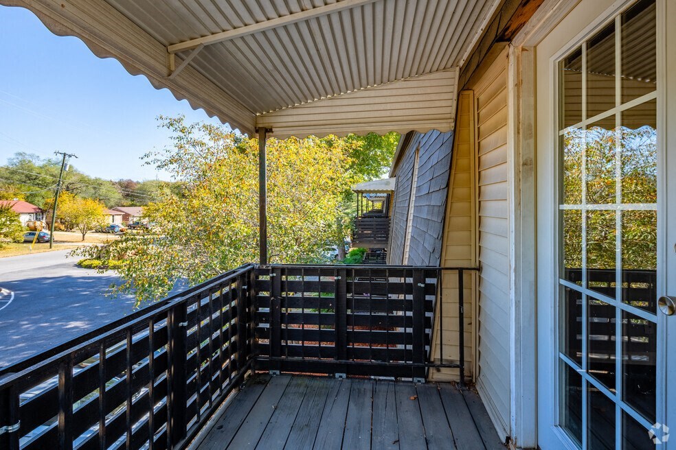 a balcony with a view of a street and trees