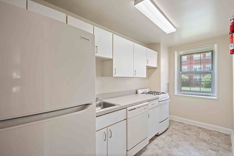 A kitchen with white appliances and cabinets.