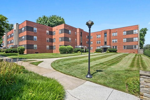 A red brick building with a green lawn in front.
