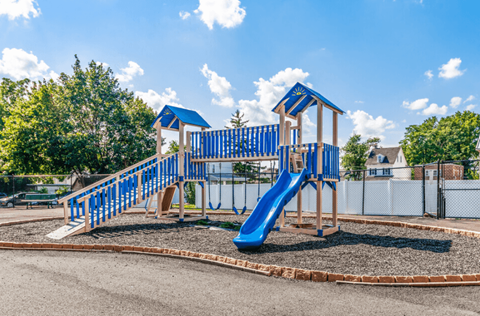 A playground with a blue slide and wooden structure.