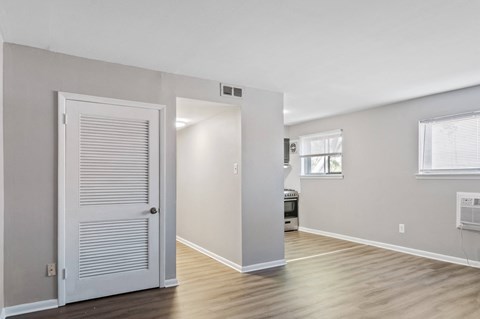 A room with a white door and a window with blinds.