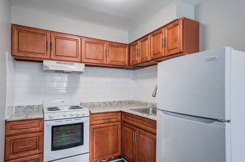 a kitchen with wood cabinets and white appliances and a refrigerator