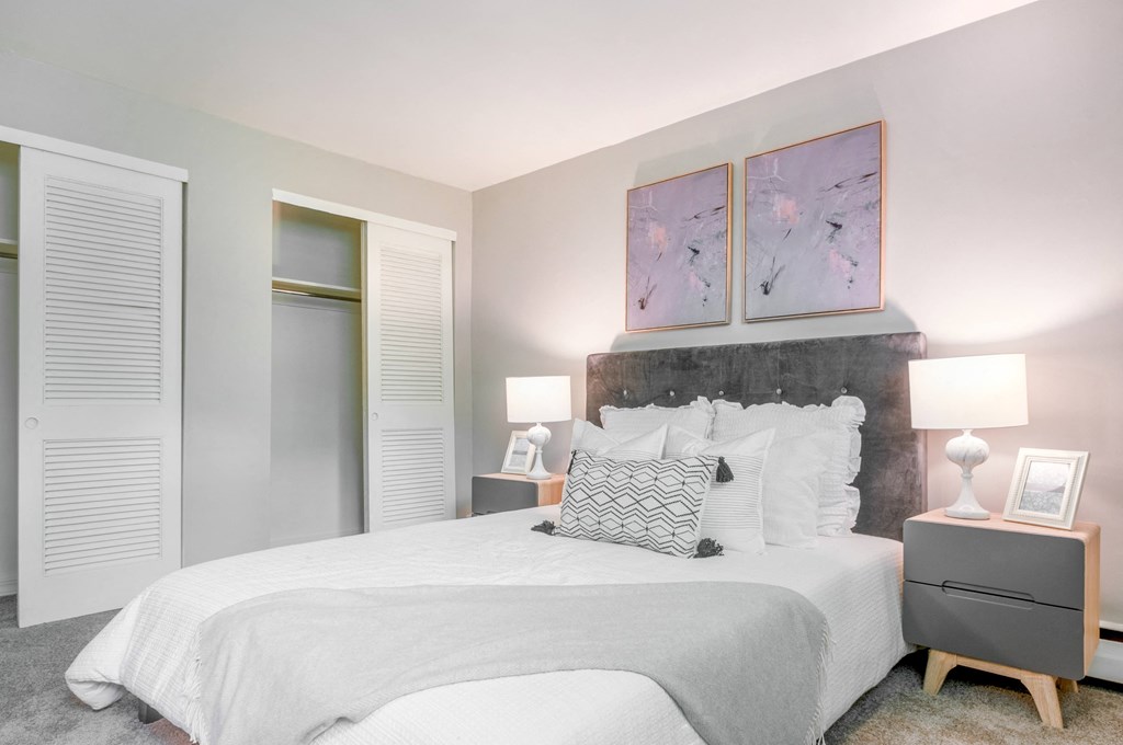 a bedroom with a large bed and two night stands with lamps