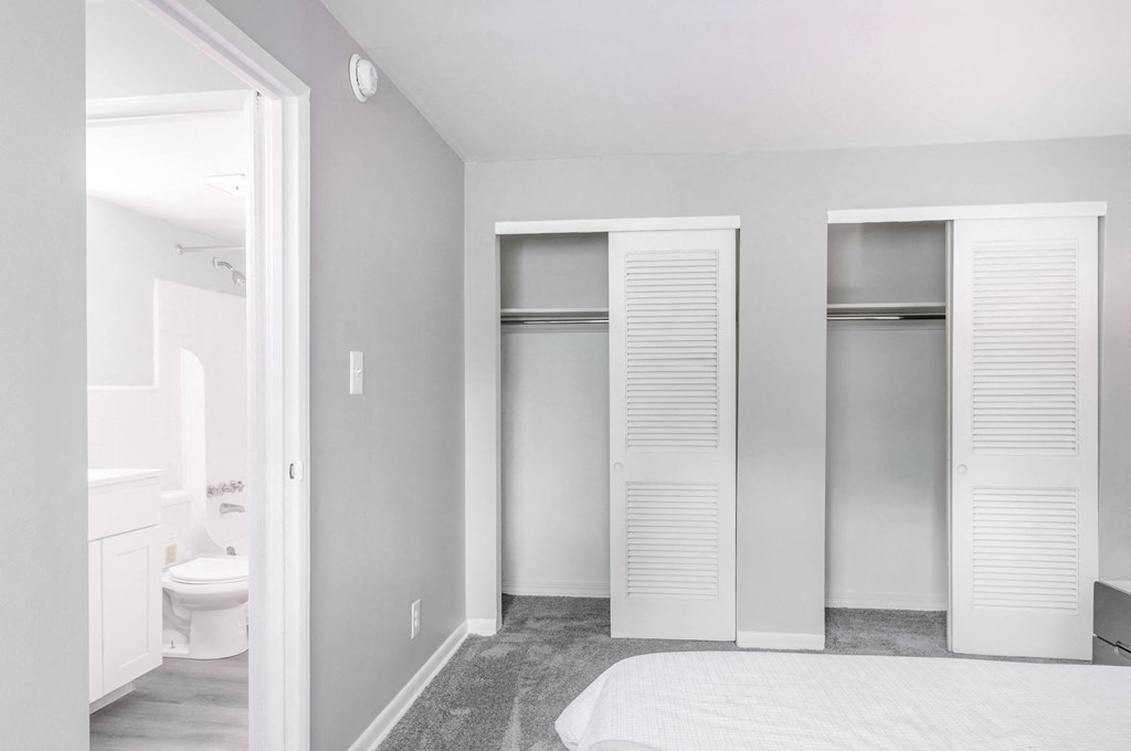 a bedroom with a bed and two closets