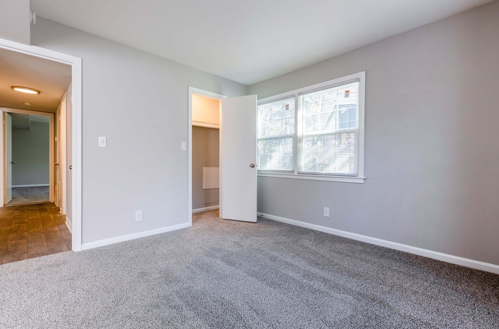 an empty living room with carpet and a large window