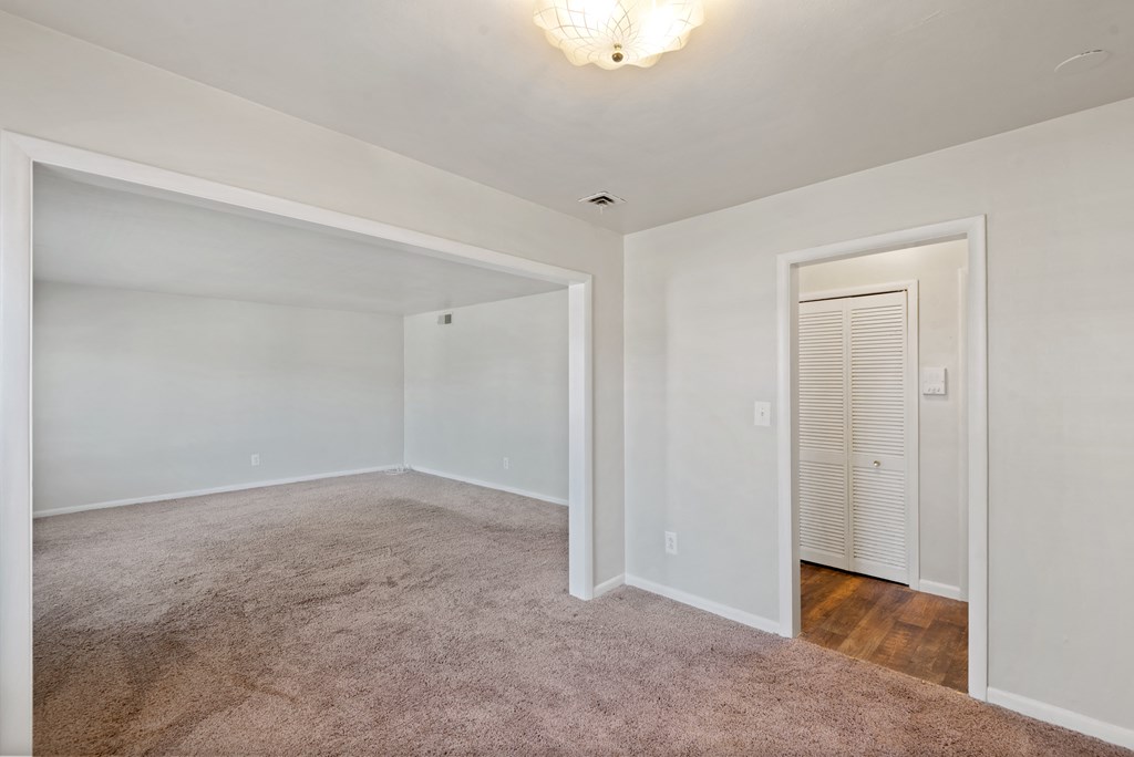 an empty bedroom with a closet and a door to the bathroom