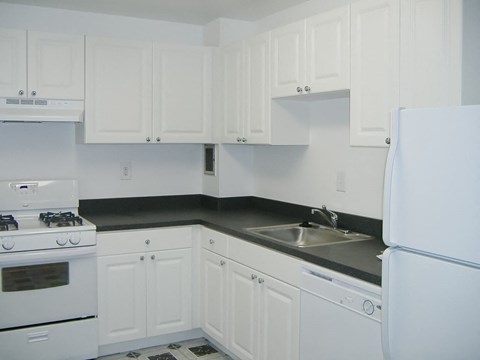 A kitchen with white appliances and cabinets.
