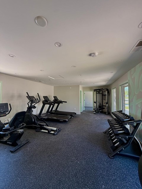 A spacious gym with treadmills, elliptical machines, and stationary bikes.