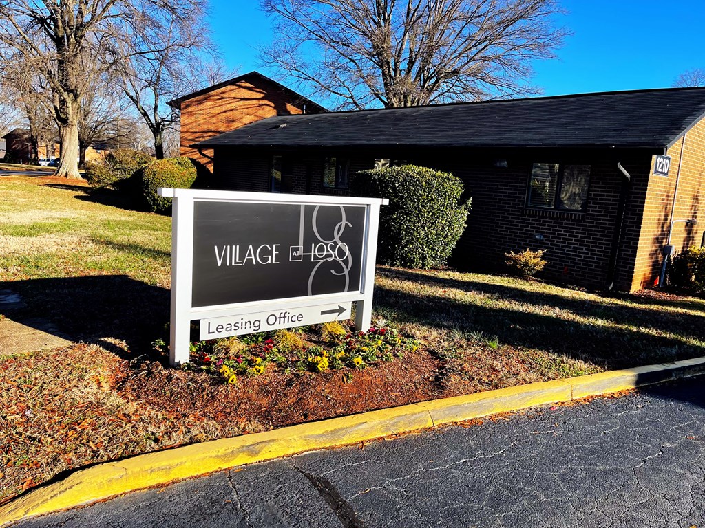 a sign in front of a house with a lease office sign