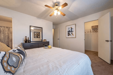 A bedroom with a large bed and a ceiling fan.
