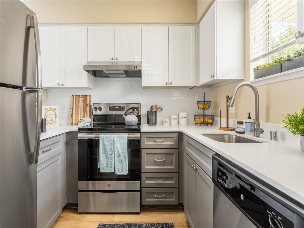 a kitchen with stainless steel appliances and white cabinets