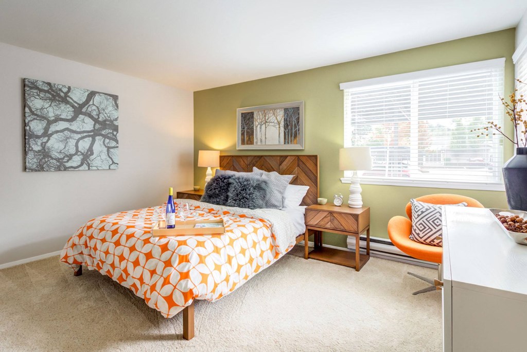 a bedroom with a bed and a desk and a window