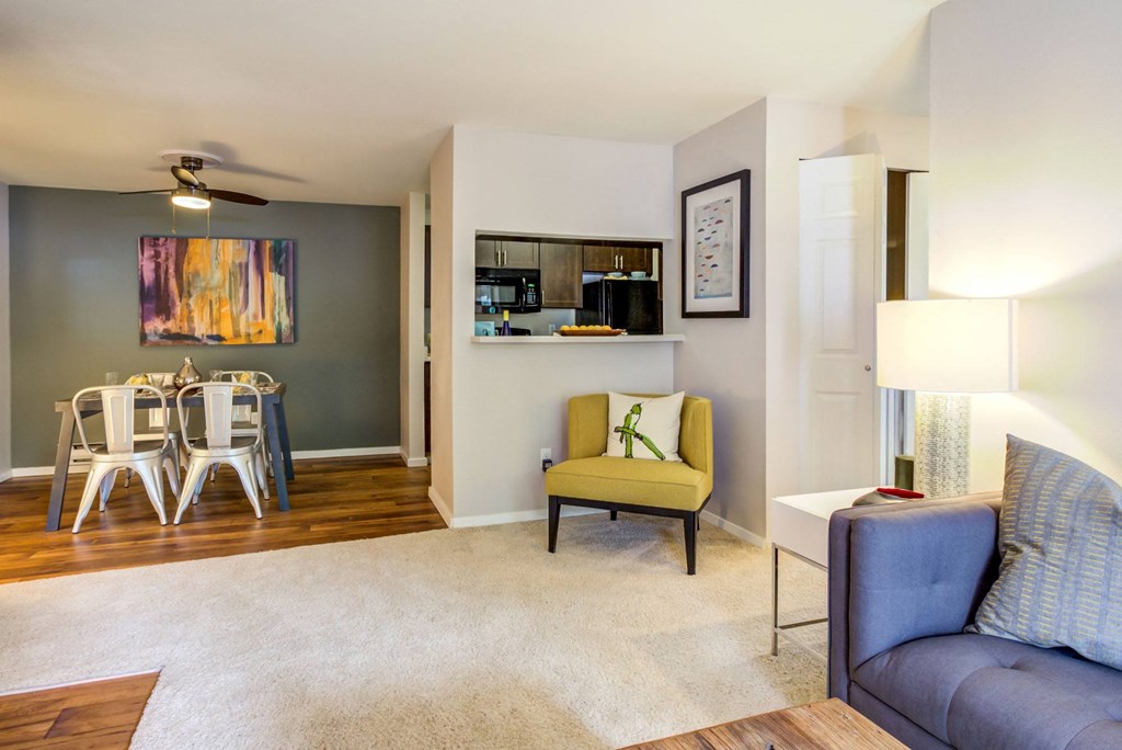 a living room with a couch and a chair and a dining table
