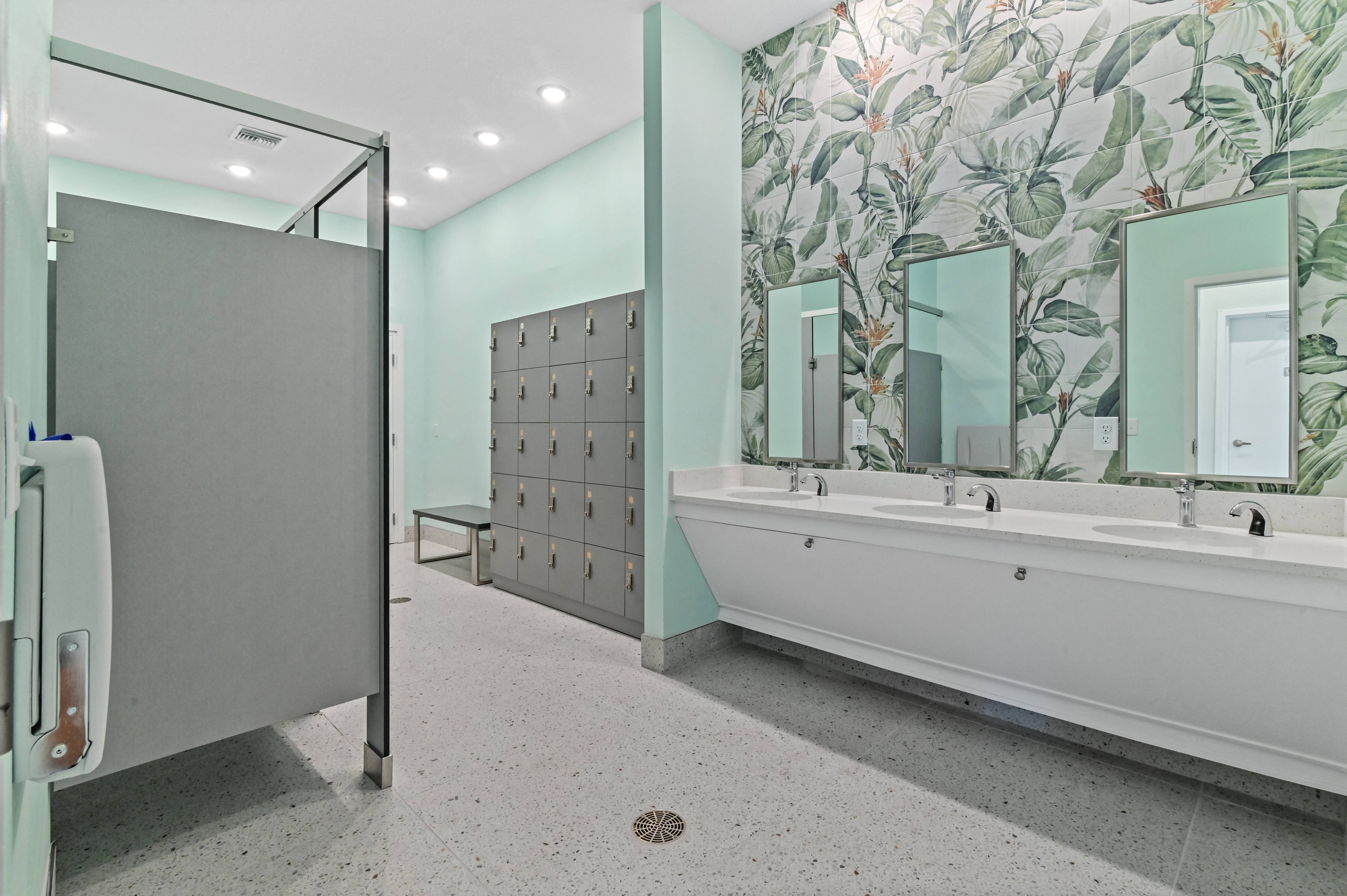 a public bathroom with a tub and a shower and a stall and a mirror