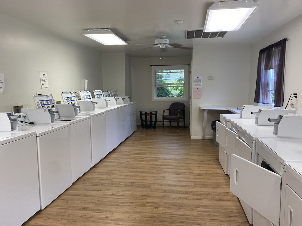 a room filled with washers and dryers in a laundry room