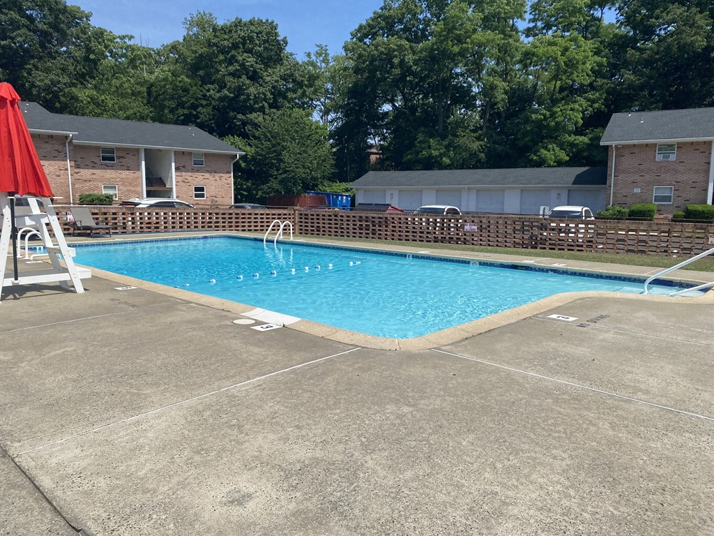 a swimming pool with an umbrella in front of a house