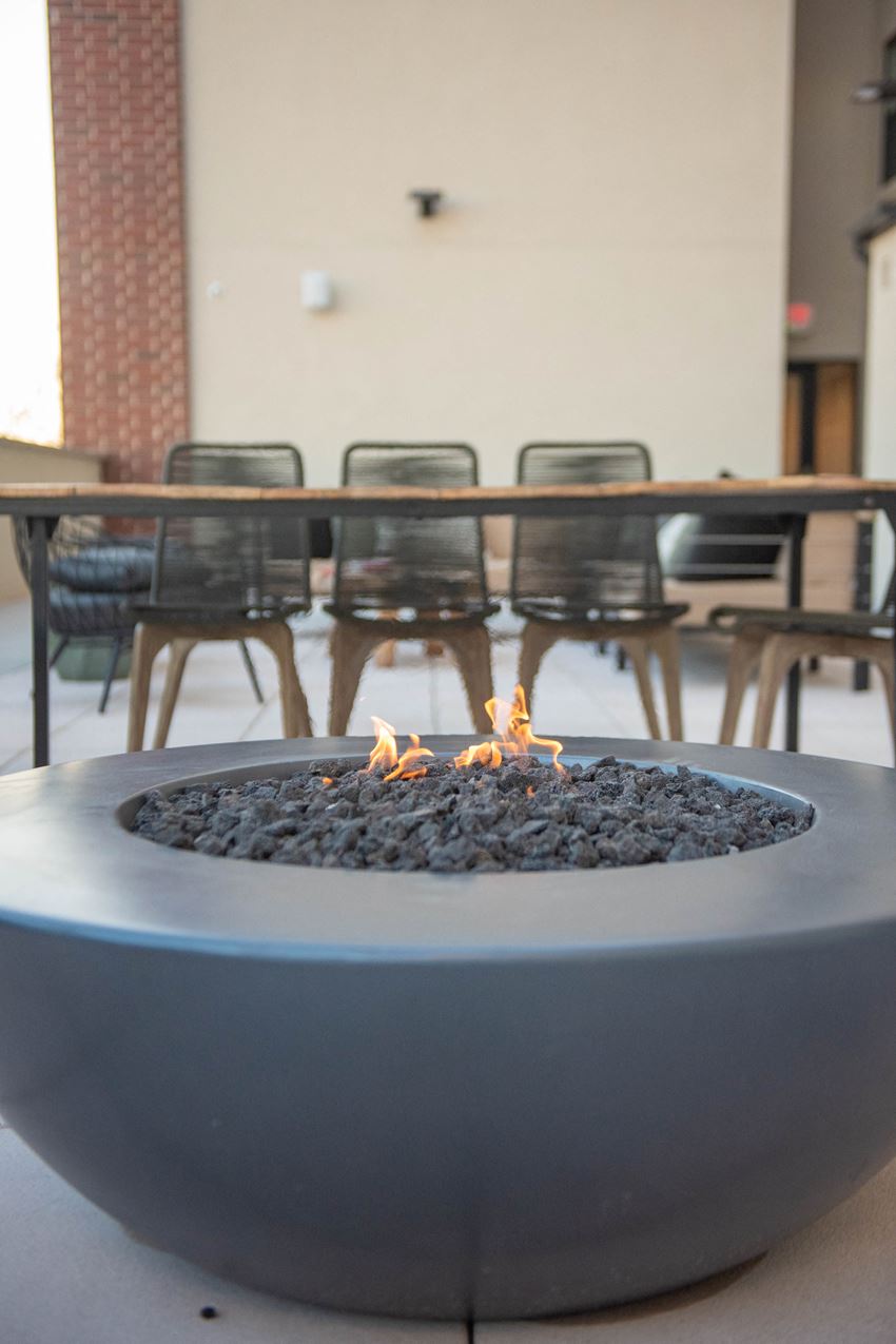 a fire pit in a room with tables and chairs