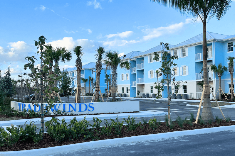 a blue and white building with palm trees in front of it