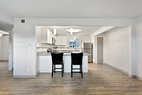 A kitchen with a table and chairs in the middle of the room.