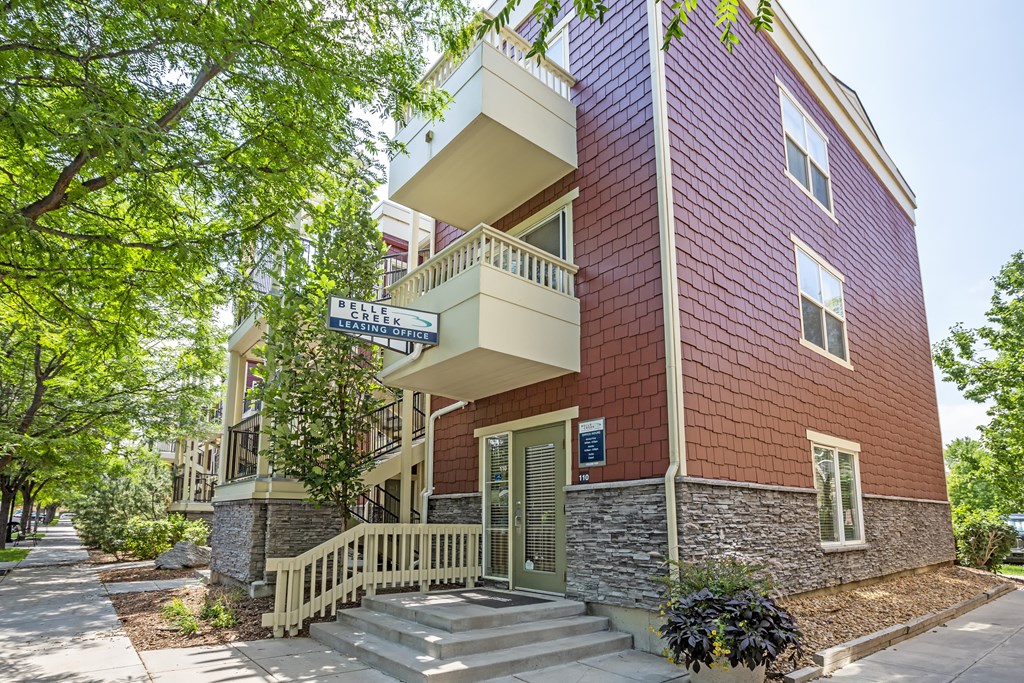 a brick apartment building with stairs and trees