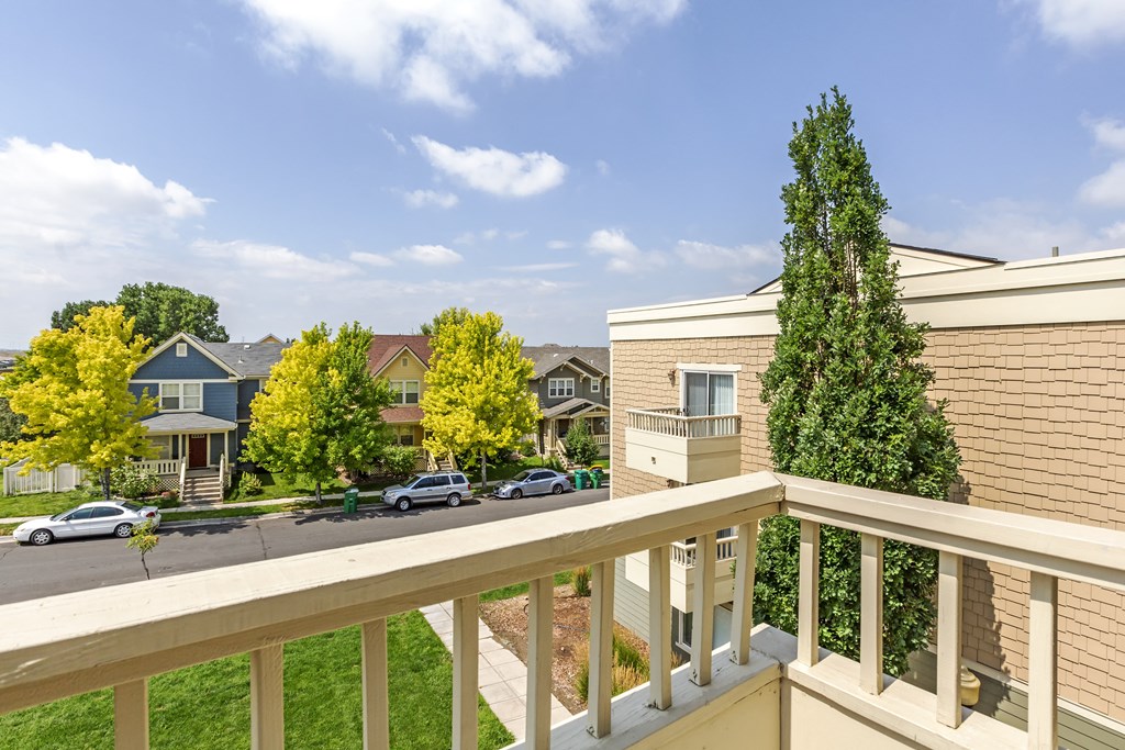 the view from the balcony of an apartment complex with cars on the street